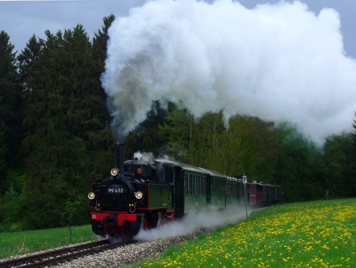 99 633 mit dem typischem 9-Wagen Planzug auf dem Weg zurück von Ochsenhausen nach Warthausen, fotografiert (und akustisch aufgenommen) in der Steigung hinter Reinstetten (etwa beim Kilometerstein 16,4), um 16:36h am 2.Mai 2015