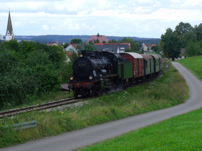 38 3199 mit Zug nach Neuffen, kurz hinter Linsenhofen, wovon im Hintergrund der Haltepunkt zu sehen ist, um  13:32h am 21.08.2016