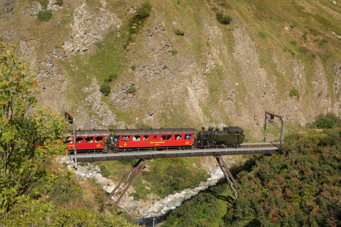 Lok 704&nbsp;Tv mit Zug Nr.154 zurück von Oberwald nach Realp abwärts fahrend, direkt auf der berühmten Steffenbachbrücke, um 15:58h am 13.08.2026