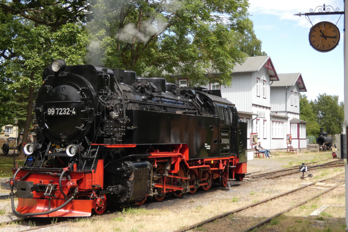 99 7232  ist vom Zug abgekuppelt, vorgezogen und erhält erst mal vor dem Umsetzen ans andere Zugende in Hasselfelde Wasser, fotografiert um 15:04h am 10.07.2025