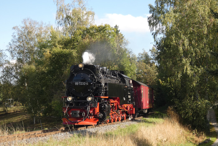 99 7232 mit Zug 8962 von Eisfelder Talmühle kommend kurz vor Hasselfelde am „Landgraben“-Bahnübergang, um 14:58h am 02.10.2025