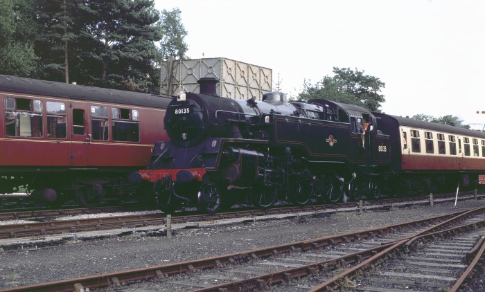 80135 mit Zug aus Pickering kommend rollt im Bahnhof Goathland ein, während vor dem haltenden Zug auf dem linken Gleis schon die 60007 auf Ausfahrt wartet, um 17:15h am 29.07.2001